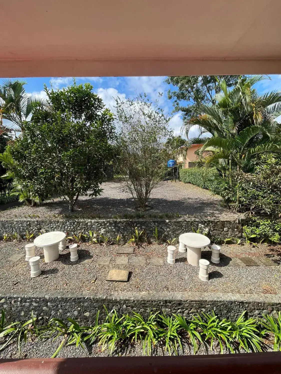 Jardín en terrazas con mesas de piedra y muros de laja