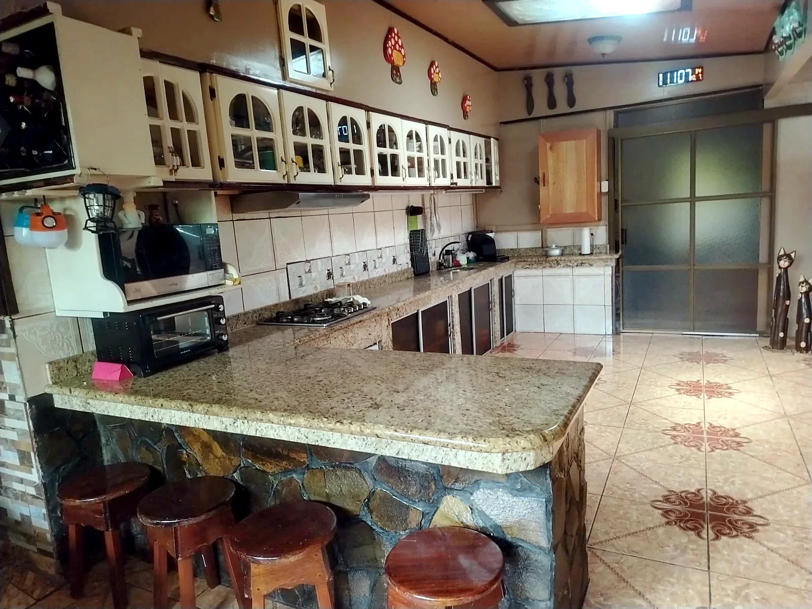Cocina amplia con mesón de granito y barra con bancos