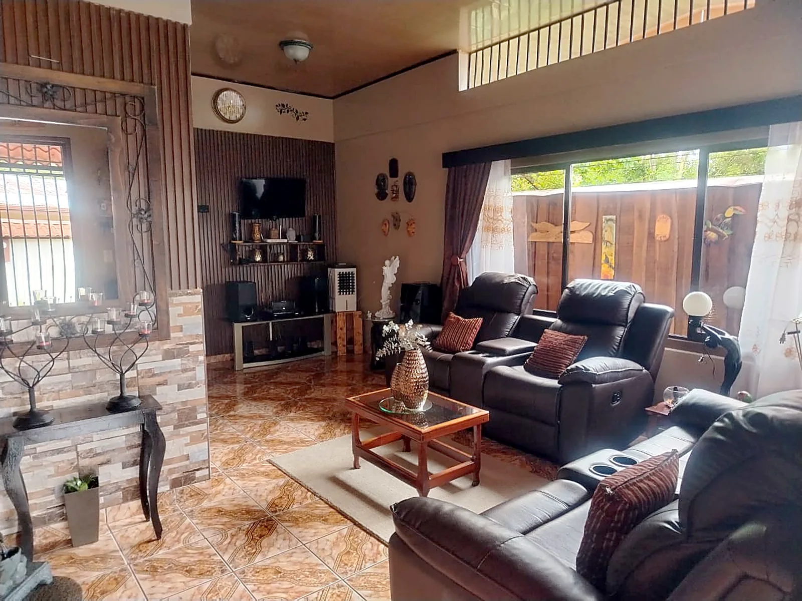 Sala con muebles reclinables y ventanales