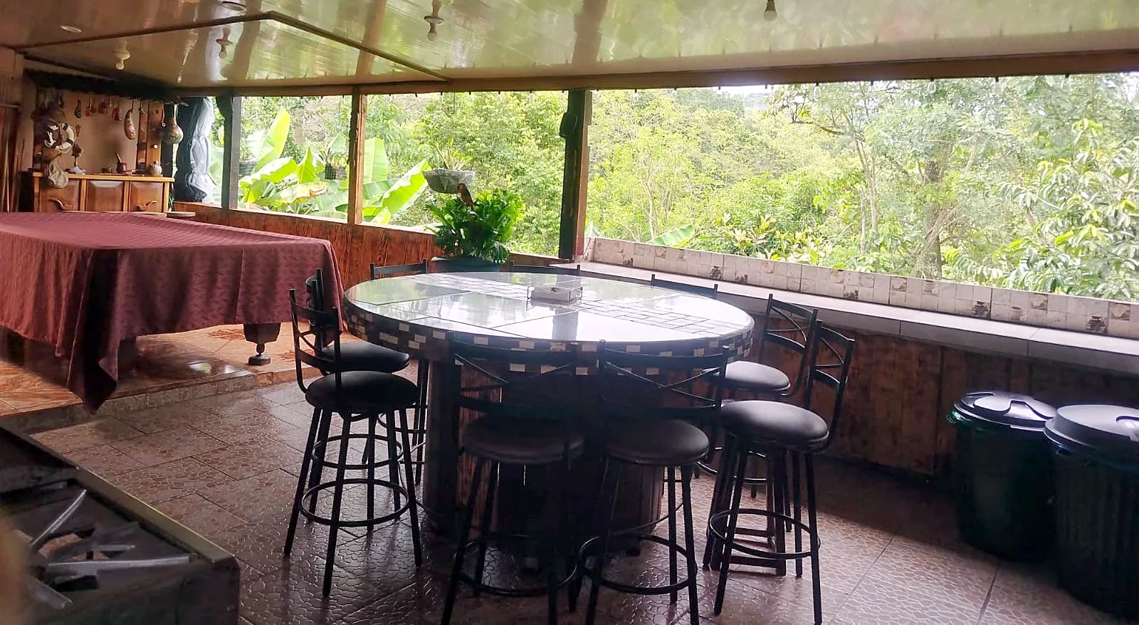 Terraza techada con área social y vista al bosque